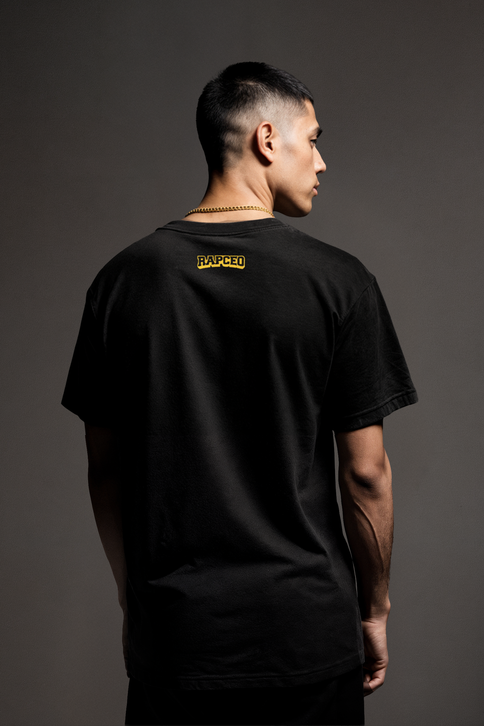 Rear view of model wearing black Silicon Don Huang t-shirt showing small yellow RAPCEO logo at nape; relaxed fit; back view of tech meme tee